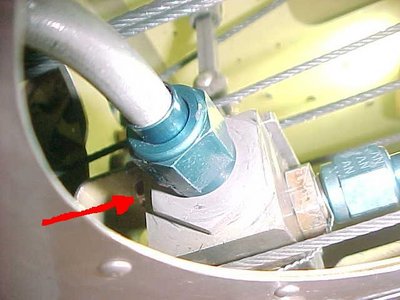The red arrow points to the right/aft mounting nut.  It cannot be accessed with an open-end wrench because of the bulkhead just aft (out of view.)  The left/aft mount nut is completely invisible and must be manipulated blindly.
